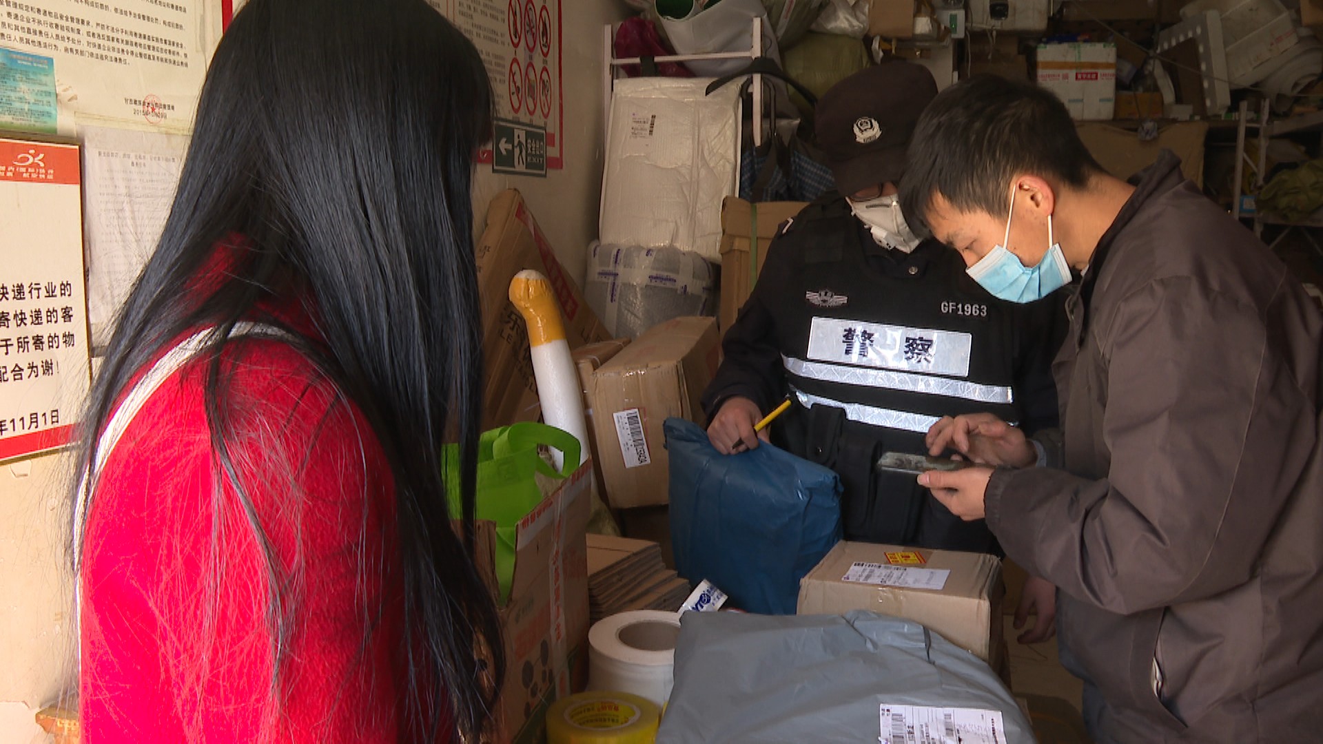 快递公司经营部看到,佩戴口罩的工作人员正在对货物进行扫码和分拣